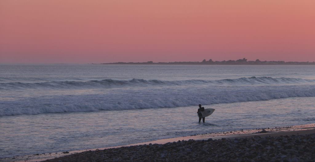 surfeur au coucher du soleil à Linès, Morbihan.