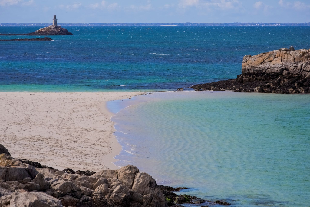 Phare et plage de sable blanc et eau turquoise à l'archipel des Glénan (Finistère)